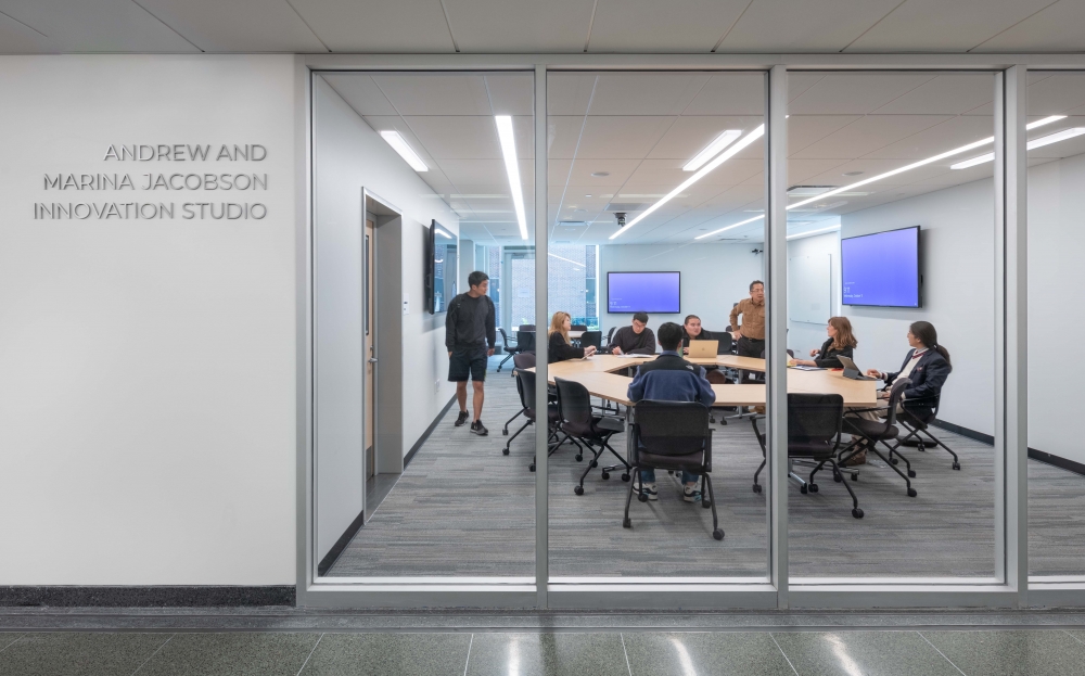 A group of people sit in a circle in the Andrew and Marina Jacobson Innovation Studio