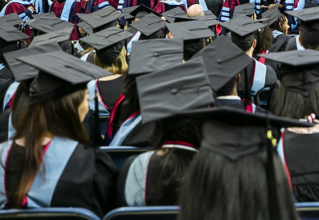People wearing mortorboards at college commmencement ceremony