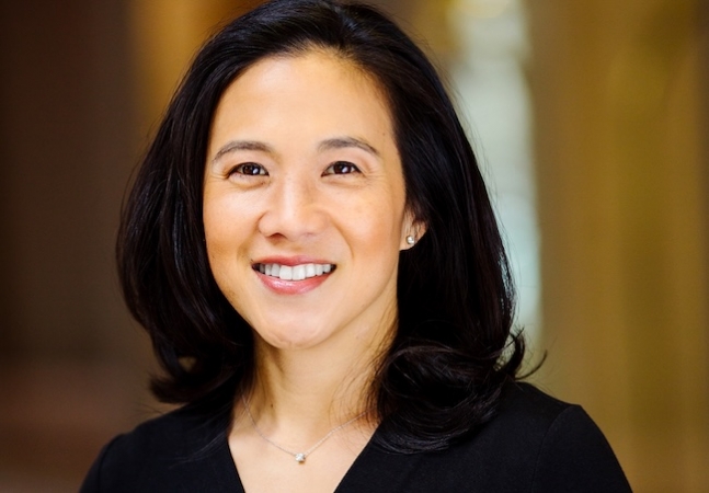 Angela smiles, wearing a black shirt