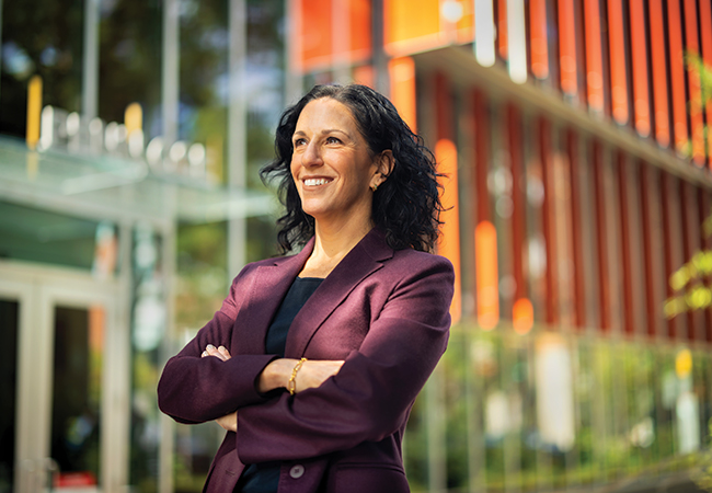 Penn GSE Dean Katharine Strunk stands arms folded in front of the entrance to the GSE building
