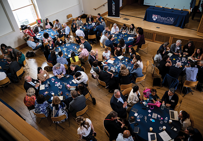 Aerial view of people sitting at round tables in a wooden floor room
