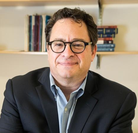 Headshot of Peter Eckel against a bookshelf
