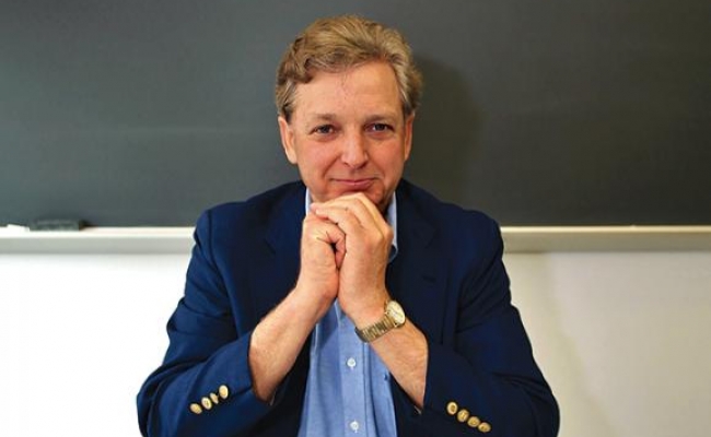 Professor sitting in front of blackboard