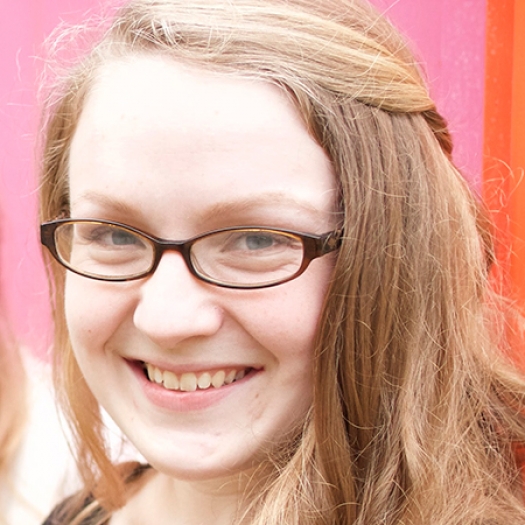 Headshot of a smiling woman wearing glasses