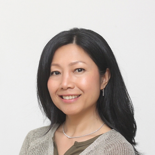 Woman smiling in front of white wall