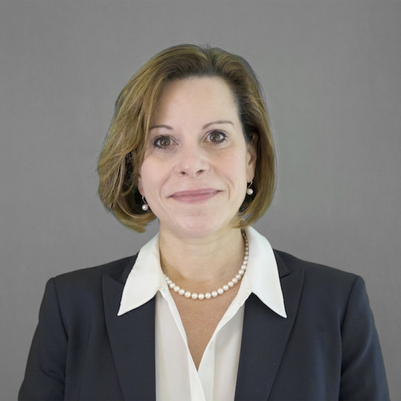Woman with short hair and pearl necklace. 
